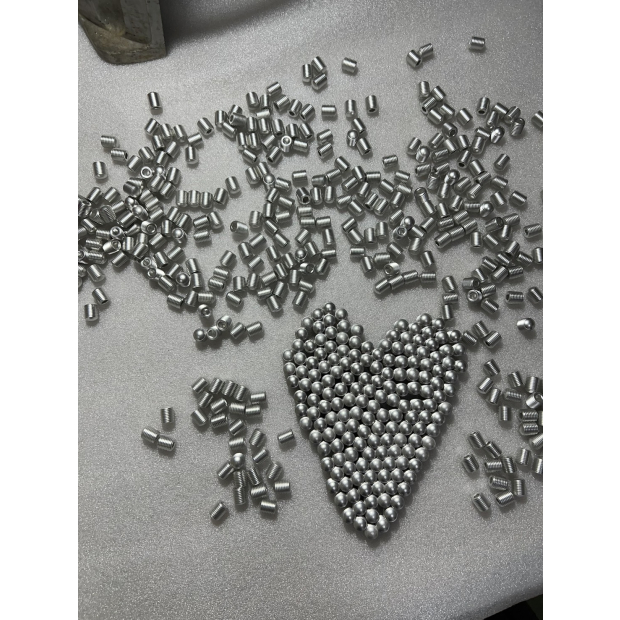 大量鋁合金螺牙件與圓球件完成鍍錫後散落展示，中心心形排列突顯鍍錫的一致性與量產穩定性。